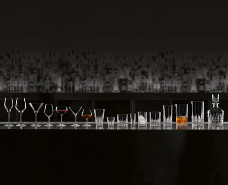 Row of various alcoholic drinks in crystal glasses on a bar tableの写真素材