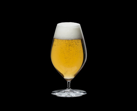 Beer glass with foam and bubbles on black backgroundの写真素材