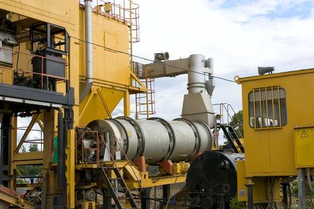 Small factory of yellow colour on asphalt manufactureの写真素材