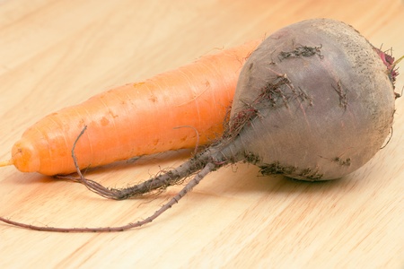 Close up crude carrots and beets on a wooden tableの写真素材