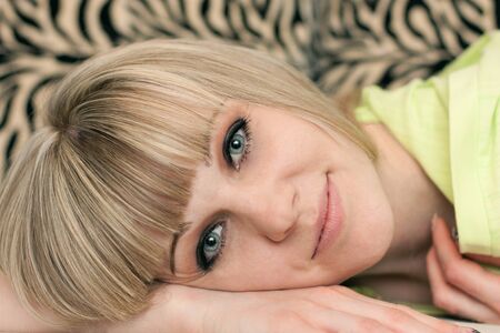 Girl's face lying on a sofa close up on a striped backgroundの写真素材