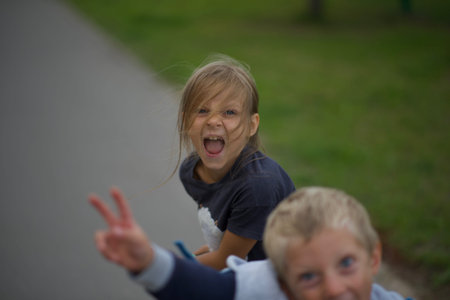 Boy and girl playing in the park. Happy family having fun together.