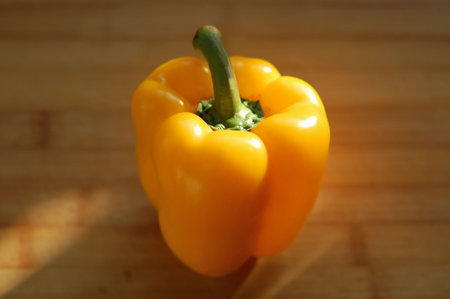 sunlit shiny ripe yellow sweet pepper on the hardboard