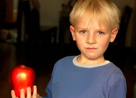 little attractive boy showing big red apple.の写真素材