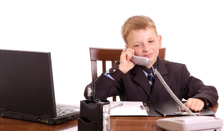 attractive boy on his working place isolated on whiteの写真素材