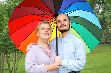 mother and son on the lawn with multi-colored umbrellaの写真素材