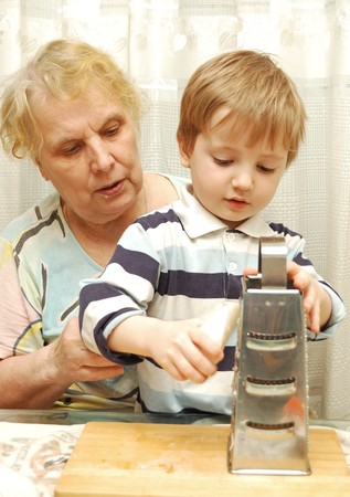 elderly woman with her grandson grate radishの写真素材