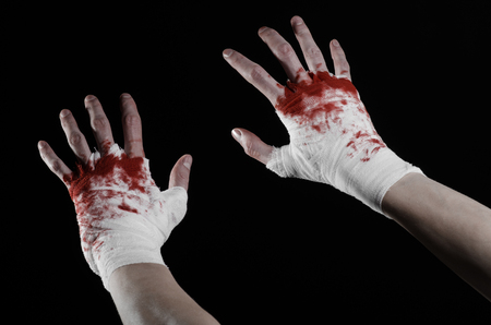 shook his bloody hand in a bandage, bloody bandage, fight club, street fight, violence, bloody theme, black background, isolated, bloody fists, boxer, tied his hands with a bandage, black background studioの写真素材
