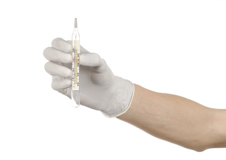 Medical theme: doctor's hand in white gloves holding a thermometer to measure the temperature of the...