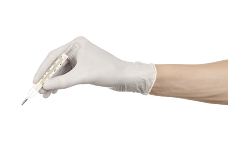 Medical theme: doctor's hand in white gloves holding a thermometer to measure the temperature of the...