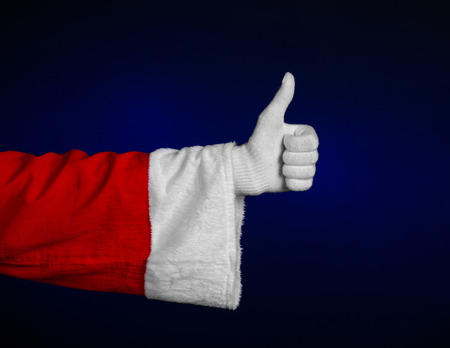 Santa Claus theme: Santa's hand showing gesture on a dark blue background studioの写真素材