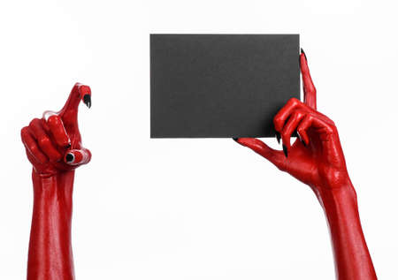 Halloween theme: Red devil hand with black nails holding a blank black card on a white background studioの写真素材