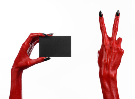 Halloween theme: Red devil hand with black nails holding a blank black card on a white background...