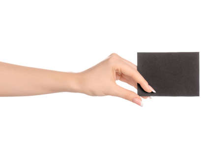 Branding and advertising theme: beautiful female hand holding empty black paper card isolated on white background studioの写真素材