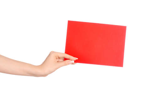 Branding and advertising theme: beautiful female hand holding a blank red paper card isolated on white background studioの写真素材