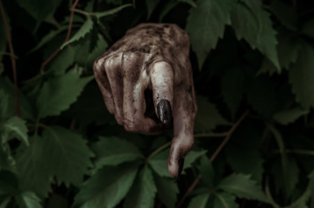 Horror and Halloween theme: terrible dirty hand with black fingernails zombie crawls out of green...