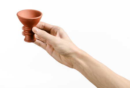 Hookah topic: Bartender holding a clay bowl for tobacco on a white background isolatedの写真素材