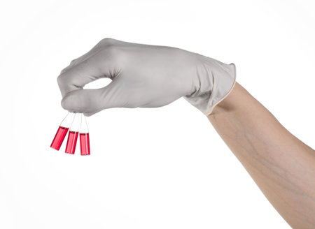 Doctor hand holding a vial, ampule red, vaccine ampule, Ebola vaccine, flu treatment, white background, isolated, gloved hand holding a vial, cancer vaccine, a vaccine against Ebola studioの写真素材