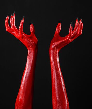 Red Devil's hands, red hands of Satan, Halloween theme, black background, isolated studioの写真素材