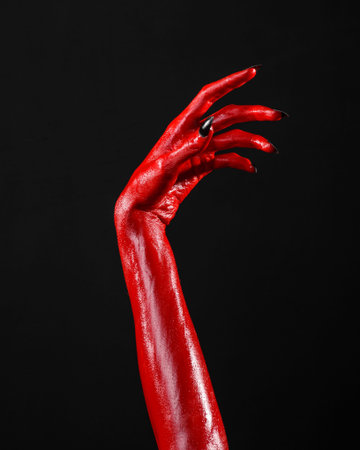Red Devil's hands, red hands of Satan, Halloween theme, black background, isolated studio