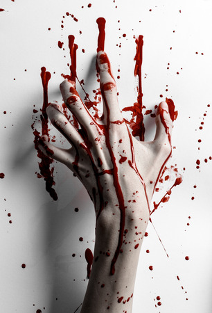Bloody halloween theme: bloody hand print on a white leaves bloody wall studioの写真素材