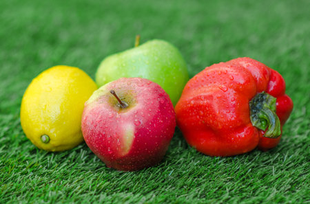 Healthy vegetarian food: the composition of fruits and vegetables in the background of green grass studioの写真素材