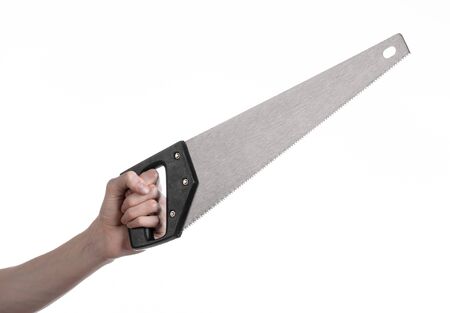 Construction topic: hand holding a saw with a black pen on a white background isolatedの写真素材