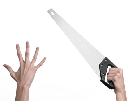 Construction topic: hand holding a saw with a black pen on a white background isolatedの写真素材