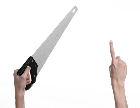 Construction topic: hand holding a saw with a black pen on a white background isolatedの写真素材