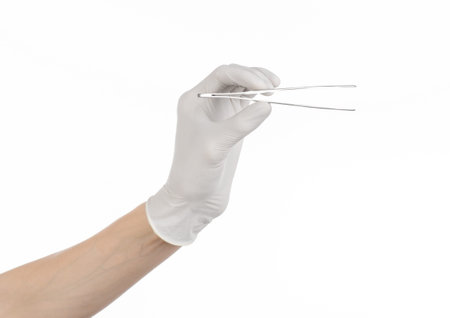 Medicine and Surgery theme: doctor's hand in a white glove holding tweezers isolated on white...