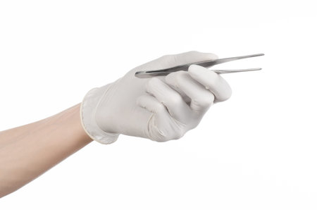 Medicine and Surgery theme: doctor's hand in a white glove holding tweezers isolated on white backgroundの写真素材