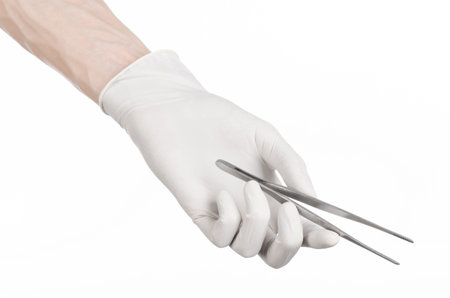 Medicine and Surgery theme: doctor's hand in a white glove holding tweezers isolated on white backgroundの写真素材