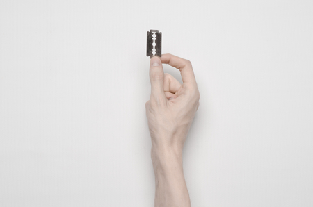 Suicide and Halloween theme: the human hand holding the blade to suicide isolated on white background top viewの写真素材