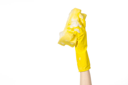 Cleaning the house and sanitation topic: Hand holding a yellow sponge wet with foam isolated on a...