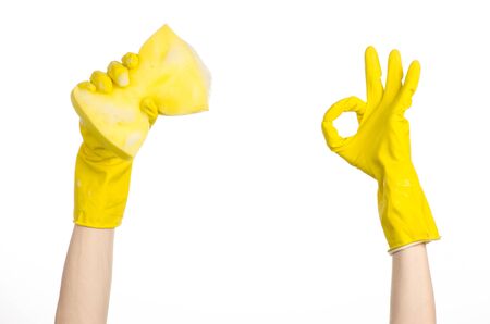 Cleaning the house and sanitation topic: Hand holding a yellow sponge wet with foam isolated on a white backgroundの写真素材