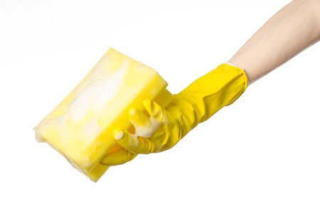 Cleaning the house and sanitation topic: Hand holding a yellow sponge wet with foam isolated on a white backgroundの写真素材