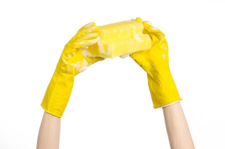 Cleaning the house and sanitation topic: Hand holding a yellow sponge wet with foam isolated on a white backgroundの写真素材