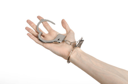 Prison and convicted topic: man hands with handcuffs isolated on white background in studio, put...
