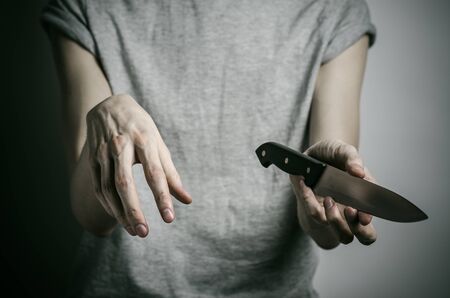 Murder and Halloween theme: a man holding a knife on a gray background studioの写真素材