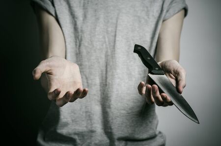 Murder and Halloween theme: a man holding a knife on a gray background studioの写真素材