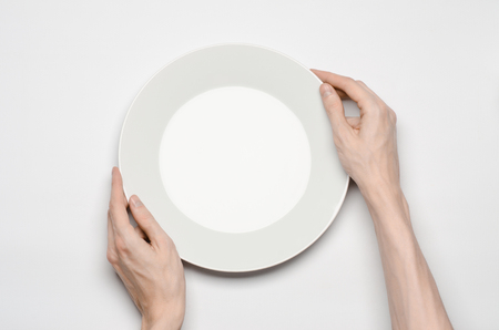 Restaurant and Food theme: the human hand show gesture on an empty white plate on a white background isolated top viewの写真素材
