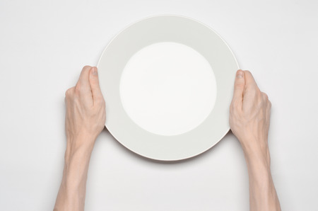 Restaurant and Food theme: the human hand show gesture on an empty white plate on a white background isolated top viewの写真素材