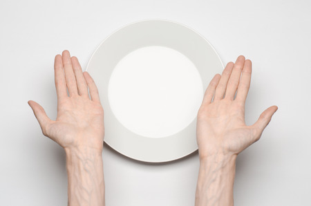 Restaurant and Food theme: the human hand show gesture on an empty white plate on a white background isolated top viewの写真素材