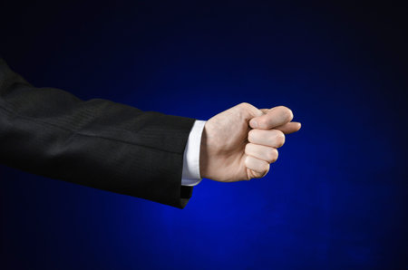Businessman and gesture topic: a man in a black suit and white shirt showing hand gesture on an...