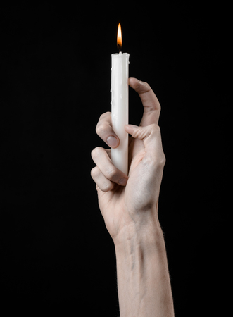hands holding a candle, a candle is lit, black background, solitude, warmth, in the dark, Hands death, hands witchの写真素材