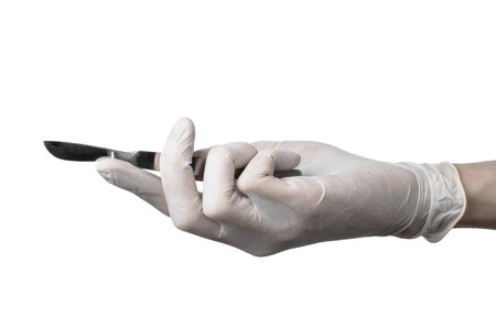Scalpel in hand in glove on white background, isolated studioの写真素材