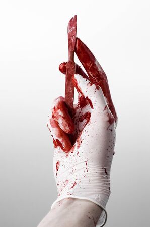 Bloody hands in gloves with the scalpel, white background, isolated, doctor, killer, maniac studioの写真素材