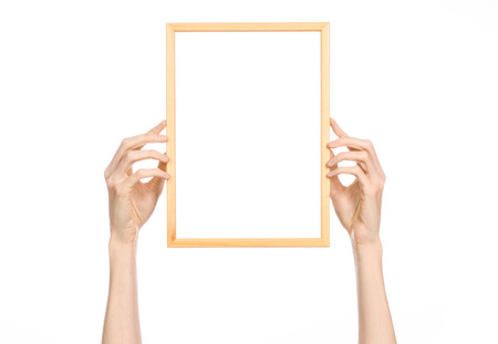 House decoration and Photo Frame topic: human hand holding a wooden picture frame isolated on a white backgroundの写真素材