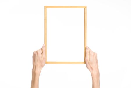 House decoration and Photo Frame topic: human hand holding a wooden picture frame isolated on a white backgroundの写真素材