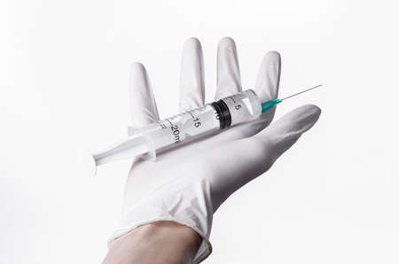 Doctor's hand holding a syringe, white-gloved hand, a large syringe, medical issue, the doctor makes an injection, white background, isolated, white gloves doctorの写真素材
